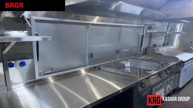 Mobile Solutions Interior of a stainless steel food trailer kitchen with a griddle and burners