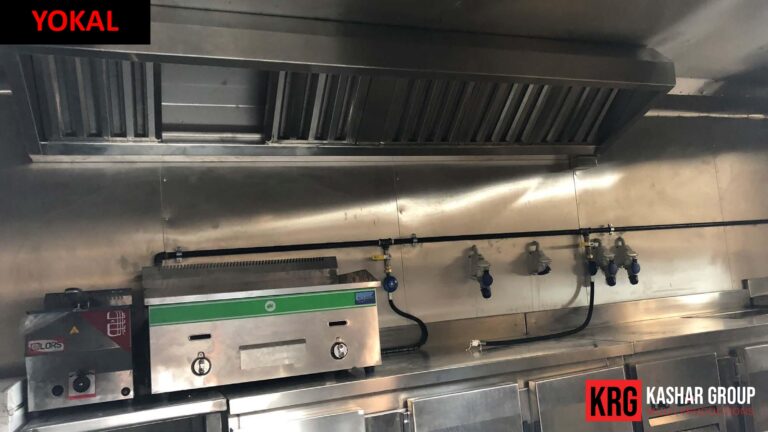 Mobile Solutions Commercial kitchen setup with stainless steel range hood, gas lines, and food trailer equipment