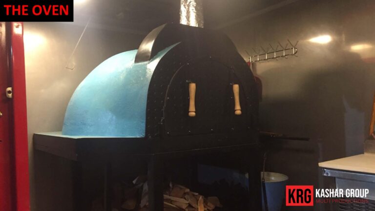 Mobile Solutions Blue-domed pizza oven inside a food trailer, with "THE OVEN" text overlay