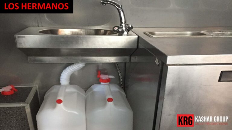 Mobile Solutions Food trailer sink with water jugs and "Los Hermanos" logo