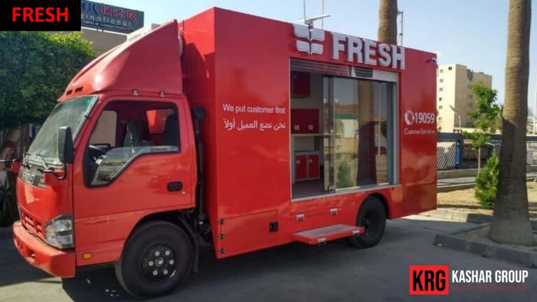 Mobile Solutions Red advertising trailer with "FRESH" logo and Arabic text parked outdoors