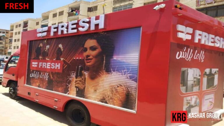 Mobile Solutions Red advertising trailer with "FRESH" branding and a woman holding a microphone