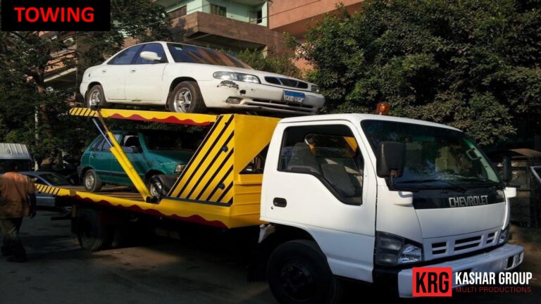 Mobile Solutions White Chevrolet wrecker towing a white sedan and a green car